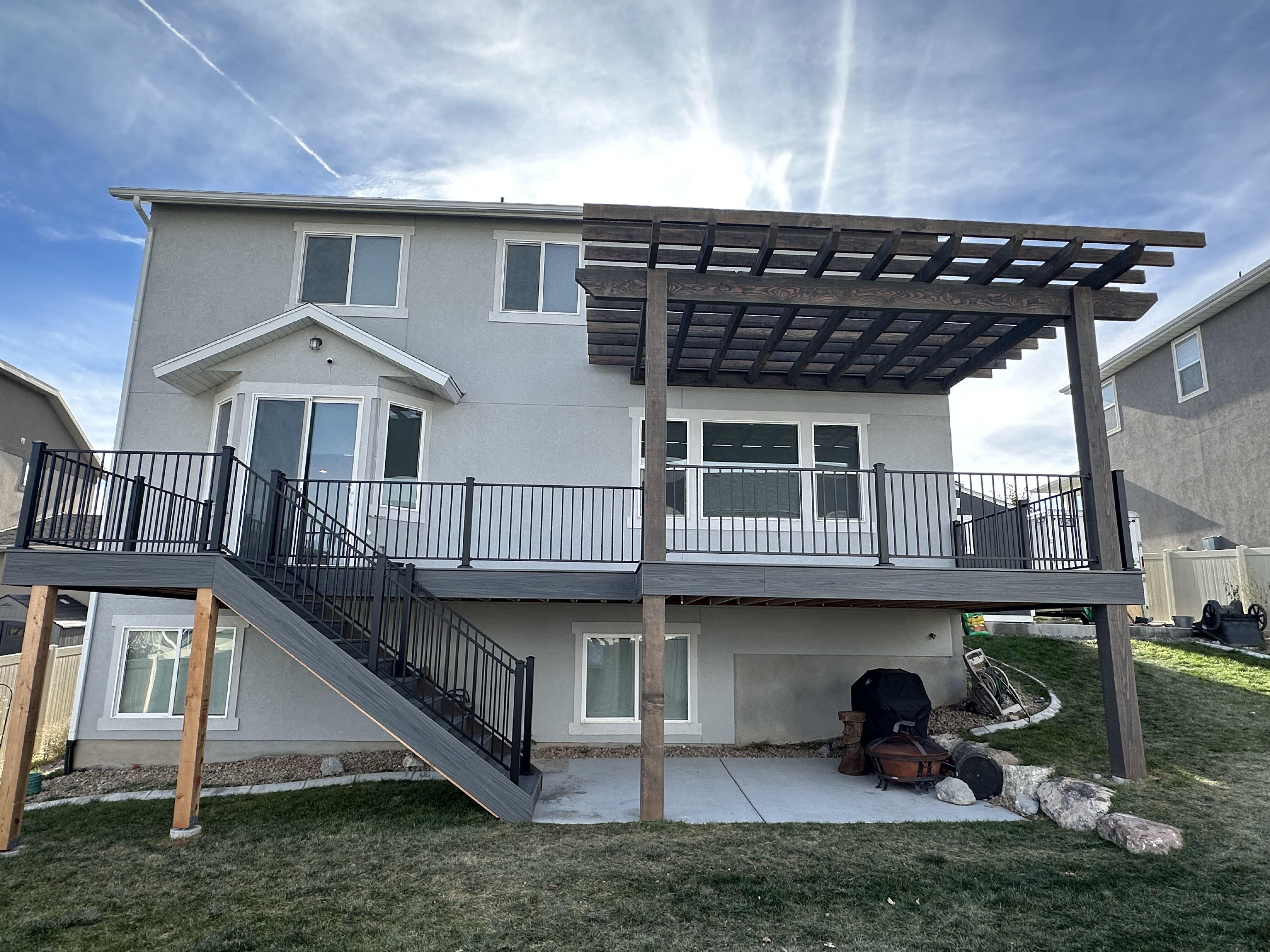 L-shaped deck wrapping our back corner. Added the pergola kit upgrade — best decision ever.